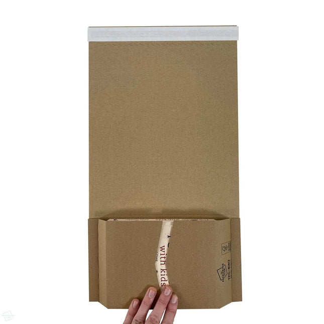 TPC-BW2 Book Wraps 248 x 165 x 0-70 mm - shot from above showing a hand holding the flaps down, inside the BW2 book wrap is a book about foraging for food with children, highlighting the fact this book wrap is ideal for shipping books