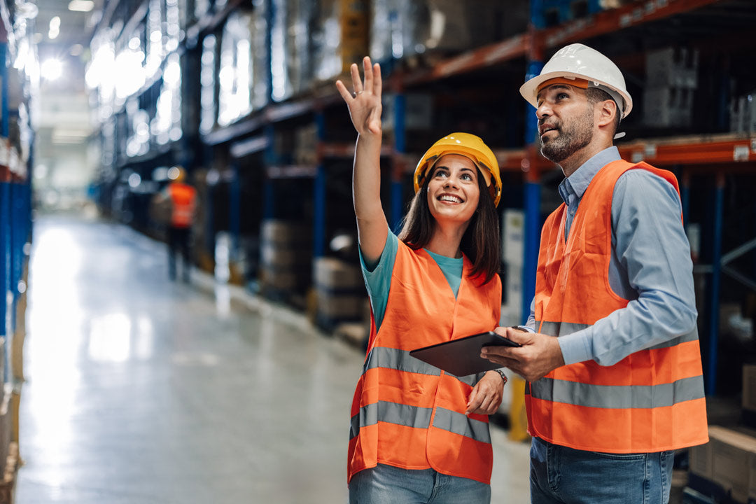 Supply chain management, 2 people, a man and a woman, both checking inventory in a warehouse