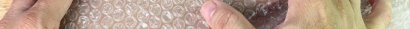 how to use bubble wrap - mage of a man placing a product wrapped in bubble wrap into a cardboard box