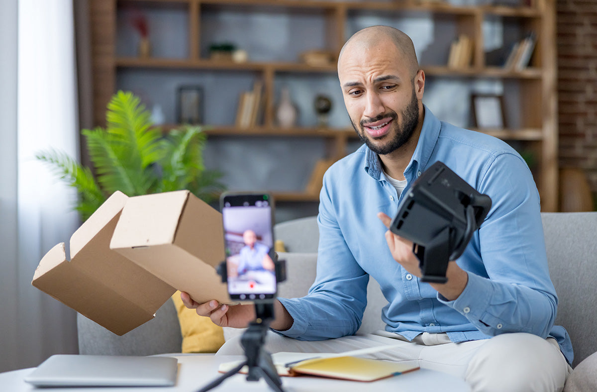 a man clearly unimpressed with how his camera was delivered, a plan brown box. 