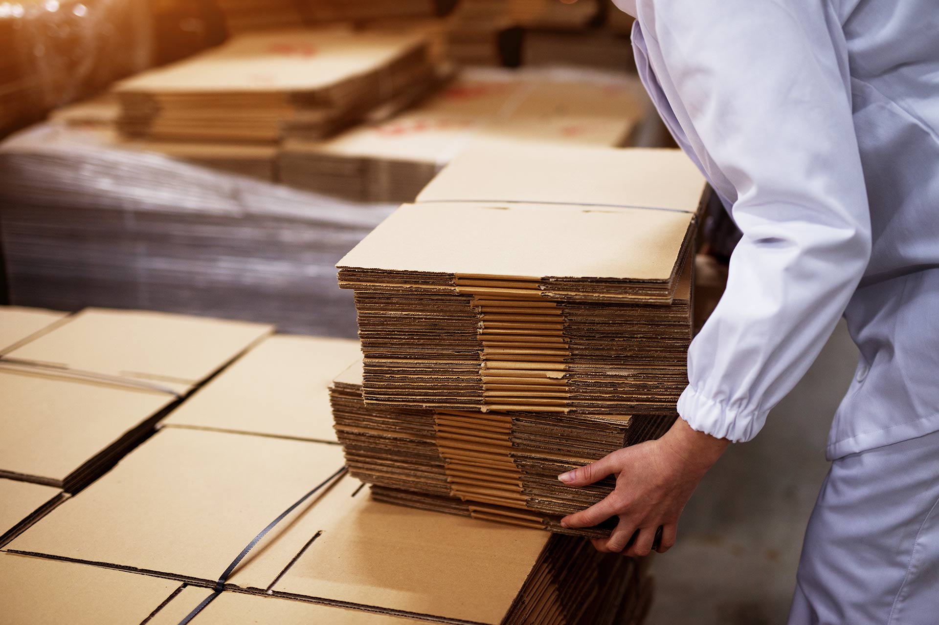 a man picking up a stack of cardboard boxes, how to measure a cardboard box