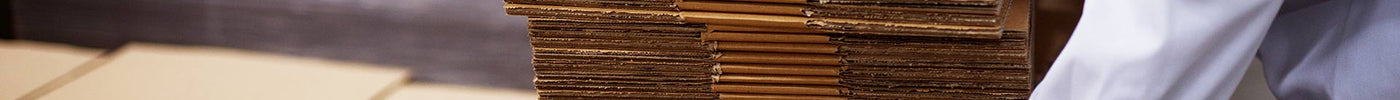 a man picking up a stack of cardboard boxes, how to measure a cardboard box