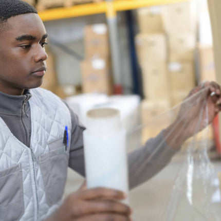 hand stretch wrap manually wrapping pallet in a warehouse