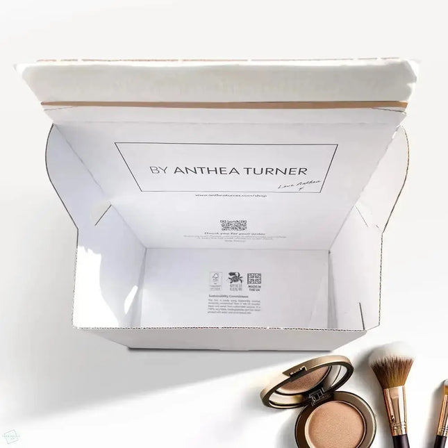 Open cosmetic crash lock delivery box by Anthea Turner with makeup items on a white background