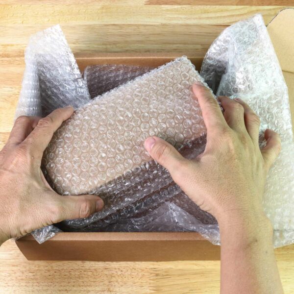 Bubble Wrap being used to pack and protect an item inside a postal cardboard box